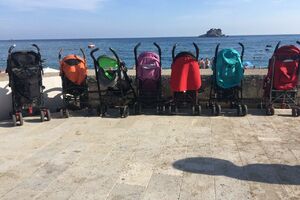 Bebe uživaju na plaži, a kolica "propisno parkirana"