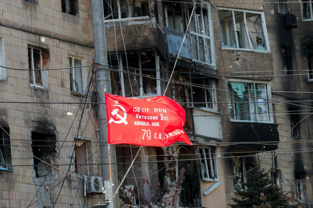 Sovjetska zastava istaknuta je povodom Dana pobjede ispred zgrade u Mariupolju, Foto: Rojters