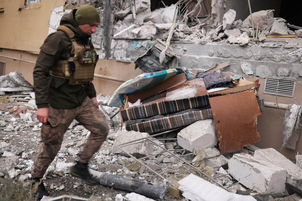 Ukrajinski vojnik uklanja grad raketu iz srušene kuće u Hersonu
