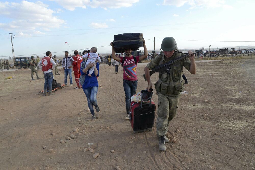 Turski vojnik pomaže sirijskim izbjeglicama, Foto: Reuters