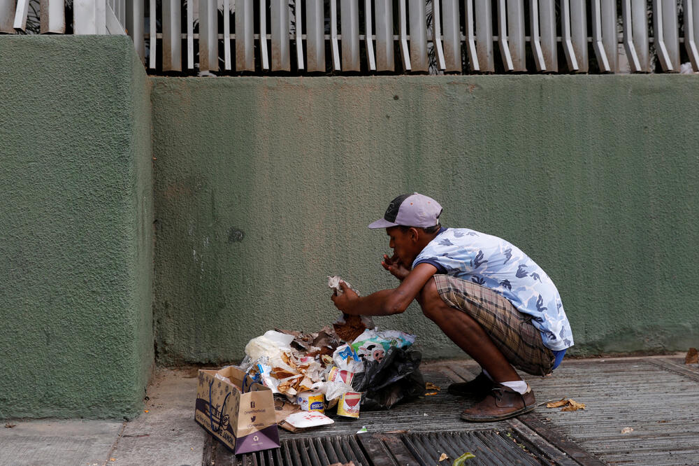 Građanin Venecuele jede hranu koju je pronašao u Kontejneru, Foto: Reuters