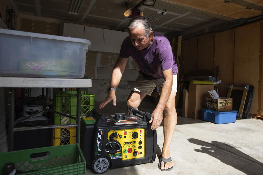 Džo Vilson priprema generator koji će pustiti u funkciju kada struja nestane, Foto: BETA/AP