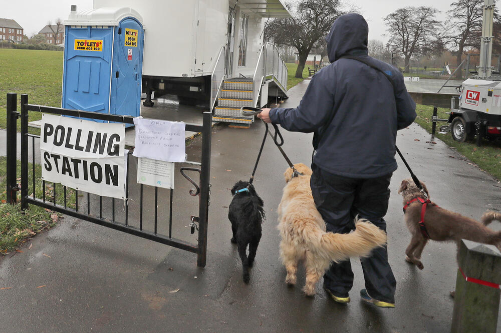 Glasač dolazi na glasačko mjesto sa psima, Foto: BETA/AP