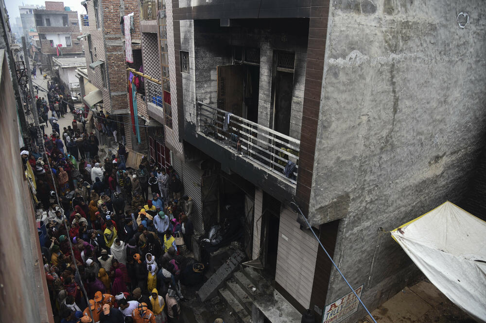 Ljudi se okupljaju oko skladišta gdje je u ranim satima ponedeljka izbio požar u oblasti Kirari u Nju Delhiju, Foto: Beta/AP