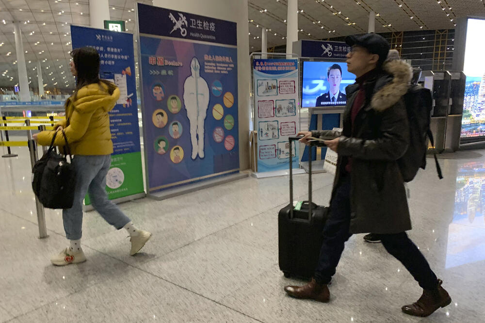 Putnici prolaze pored punkta na kojem im se provjerava zdravstveno stanje: Detalj sa aerodroma u glavnom gradu Kine, Pekingu, Foto: BETA/AP
