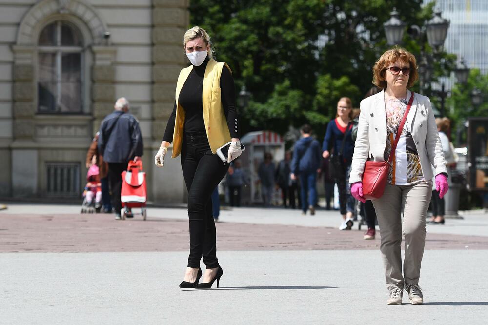 Novosađanka nosi masku za zaštitu od koronavirusa dok po sunčanom i relativno toplom vremenu prolazi kroz centar grada., Foto: Beta