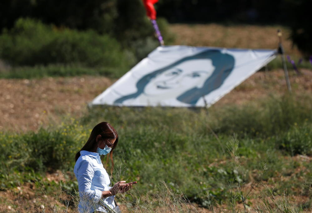 Djevojka prolazi pored banera sa likom Dafne Karuane Galicije: Komemoracija povodom tri godine od ubistva novinarke