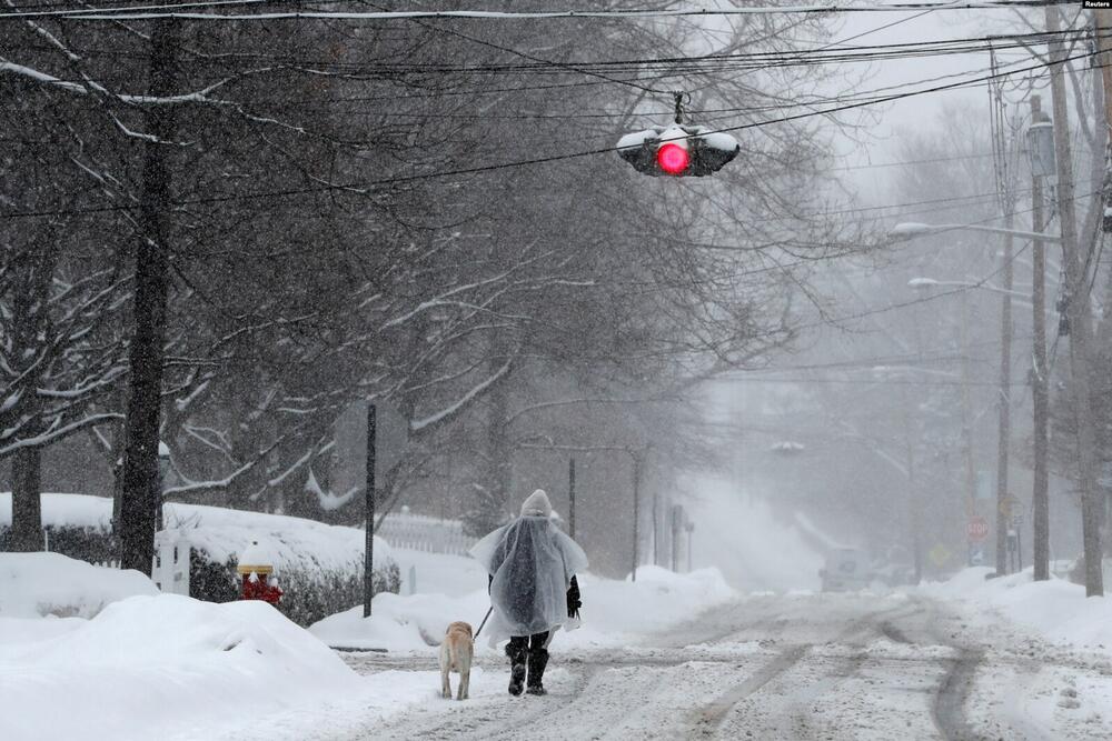 Muškarac šeta psa po snijegu tokom zimske oluje u Nyacku, predgrađu New Yorka, New York