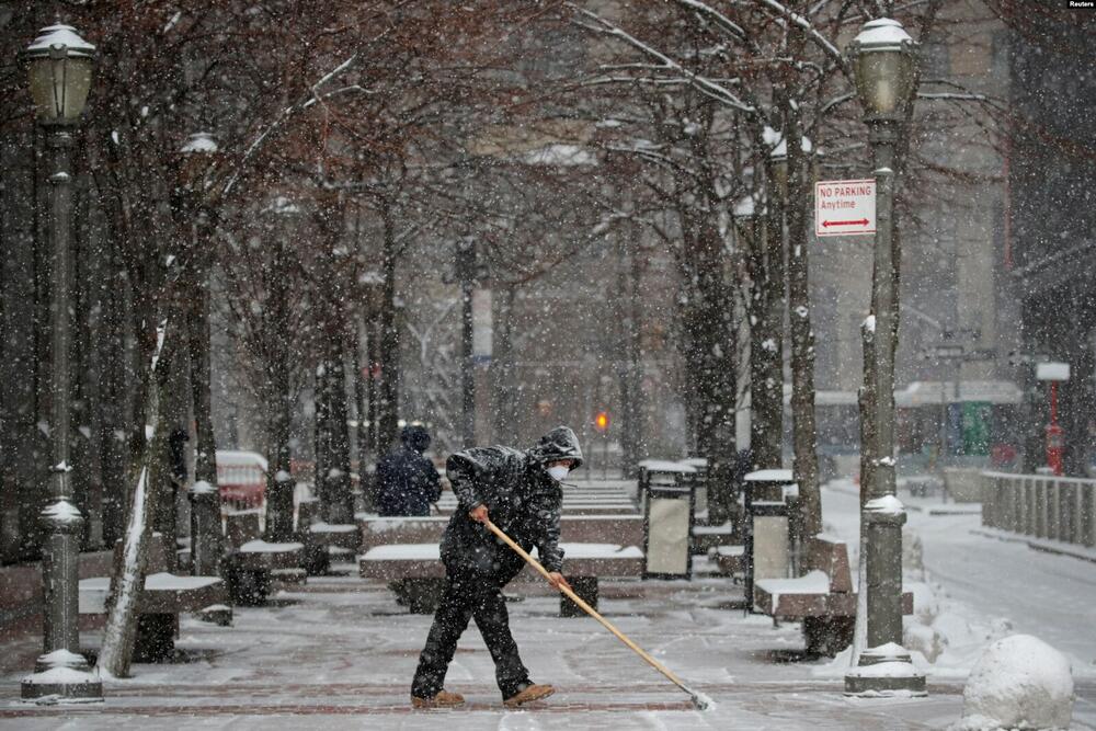 Komunalni radnik čisti snijeg sa šetališta tokom jutarnje snježne oluje u okrugu Manhattan u New Yorku