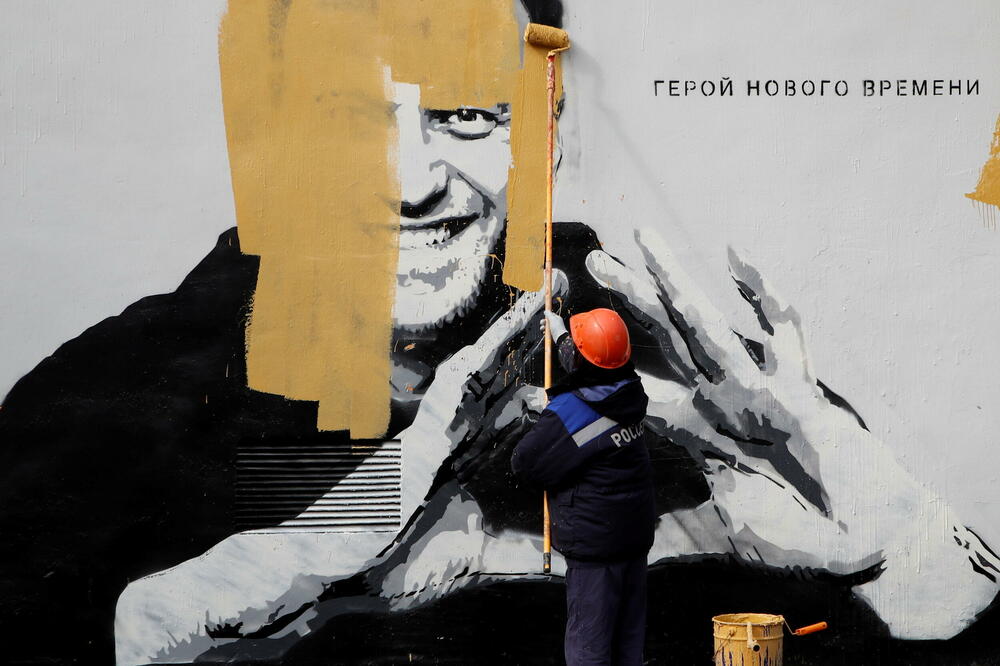 Radnik uklanja grafit Navaljnog u Sankt Peterburgu, Foto: Rojters