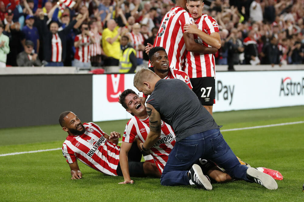 Jedan navijač je ušao na teren da slavi gol sa igračima Brentforda, Foto: Reuters