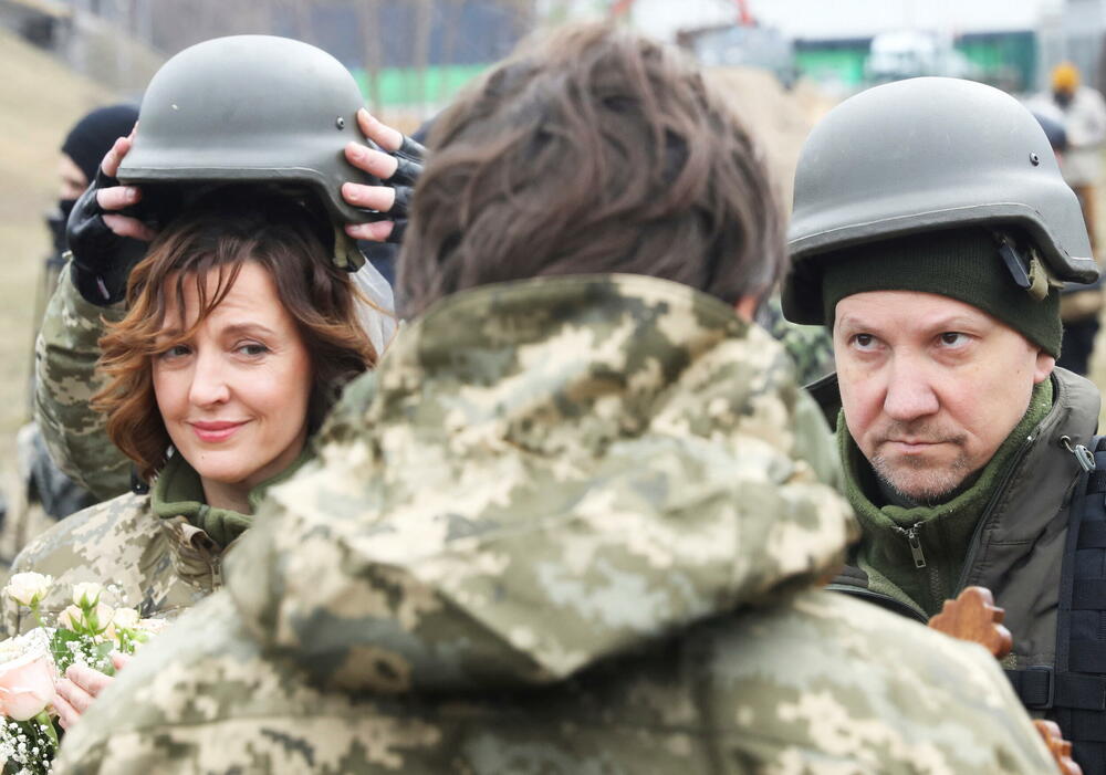 <p>Pripadnici ukrajinskih snaga teritorijalne odbrane Lesija Ivaščenko i Valerij Filimonov razmjenjuju prstenje na svom vjenčanju tokom sukoba između Ukrajine i Rusije, na kontrolnom punktu u Kijevu. U toku ceremonije bili su okruženi drugim pripadnicima ukrajinskih oružanih snaga, a prisutan je bio i gradonačelnik Kijeva Vitalij Kličko.</p>