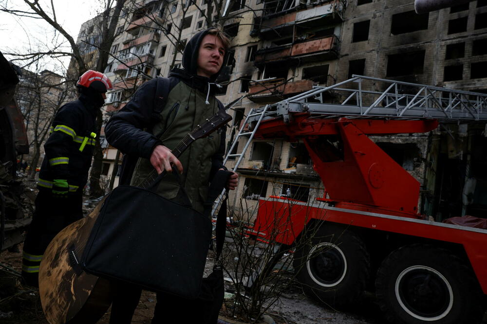 Građanin Maksim Korvi sa gitarom koju je vatrogasac izvukao iz zgrade, Foto: Reuters
