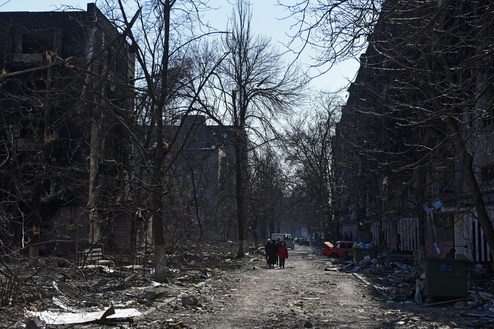 Lokalno stanovništvo šeta u blizini oštećenih stambenih zgrada Mariupolju, Foto: Reuters