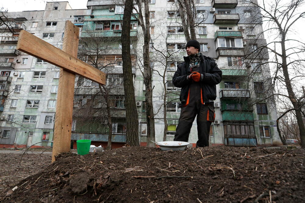 Građanin Mariupolja pored groba svog prijatelja ubijenog tokom rusko-ukrajinskog konflikta, Foto: Reuters