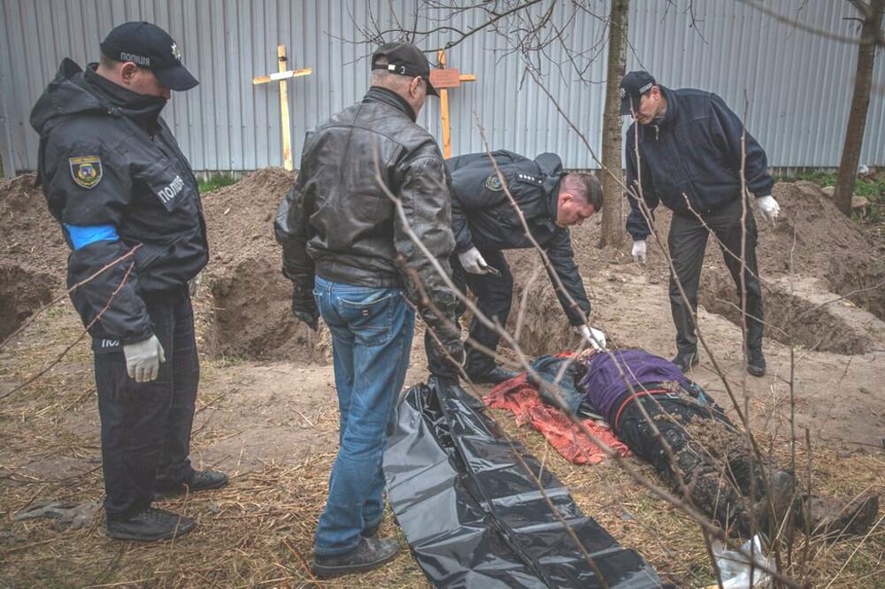 Policija u Buči vrši uviđaj na telu iskopanom u polju. Pronađeno je najmanje 500 mrtvih otkako su otišli Rusi., Foto: BBC