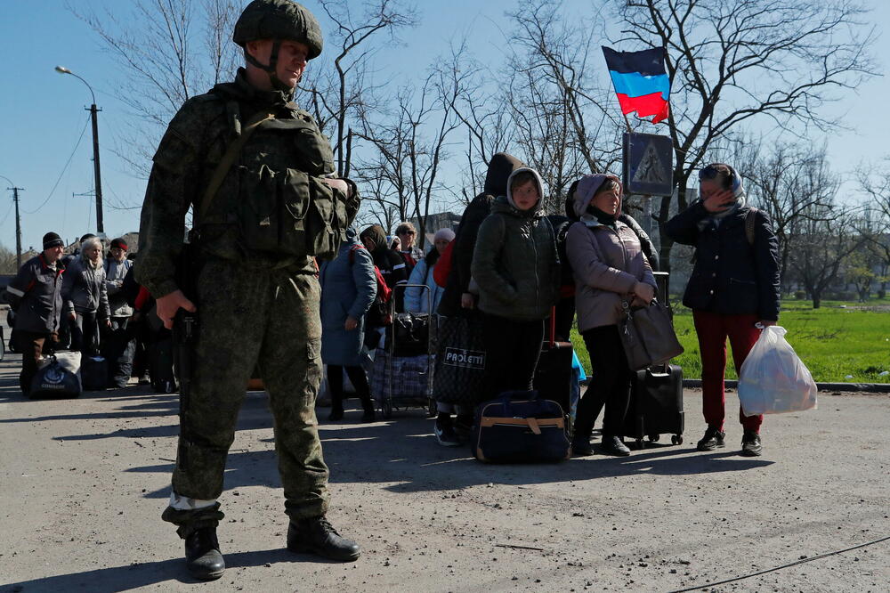 Građani Mariupolja čekaju autobus za evakuaciju u pratnji pripadnika proruskih snaga, Foto: REUTERS