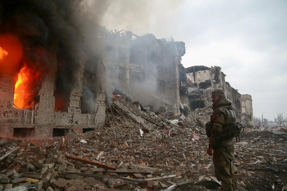 Ruski vojnik ispred uništene upravne zgrade željezare Azovstal, Foto: Reuters