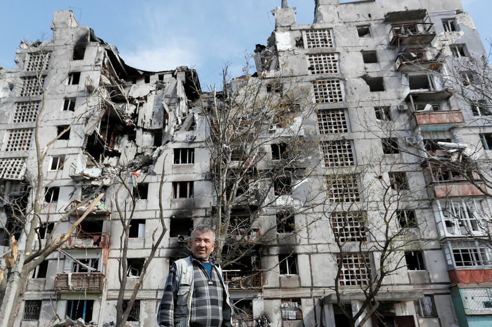 Lokalni stanovnik u blizini oštećenog stambenog bloka u Mariupolju, Foto: Reuters