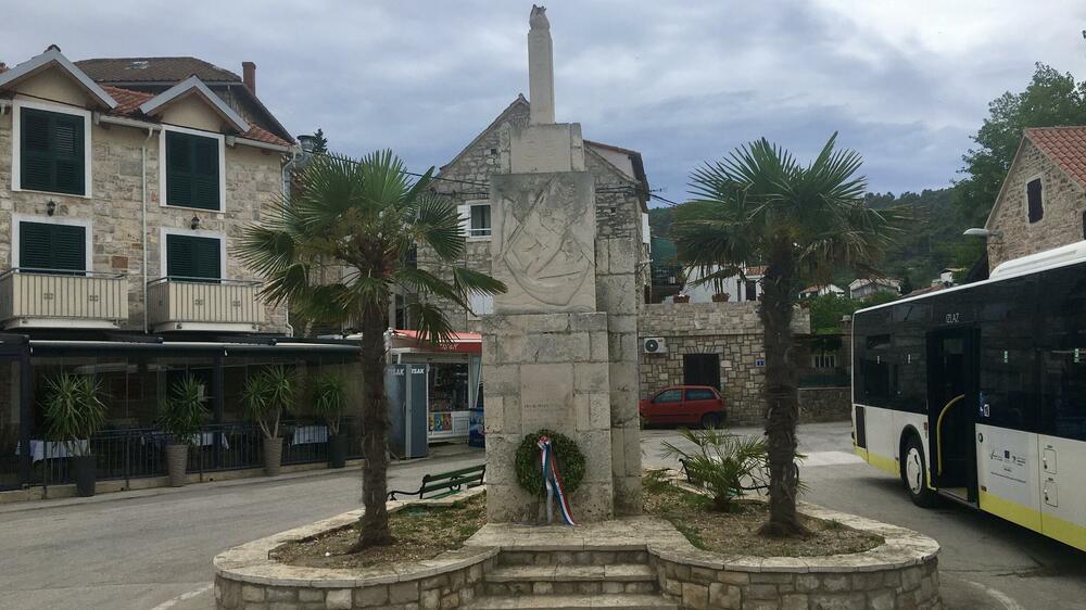 <p>Nenašminkane kuće od kamena, stare masline i smokve, makija. More miluje stijene. Zimzeleno rastinje, izraslo na vjetru, nadnijelo se nad kristalnobistru vodu. Jedan se čovjek zabavio čišćenjem svoje barke u luci</p>