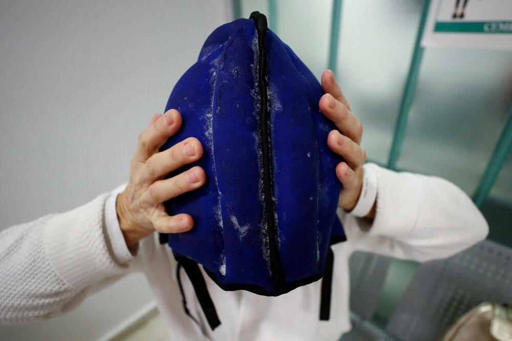 Pacijentkinja Elsa Ram namješta kapu za hlađenje uoči primanja hemoterapije, Foto: Rojters