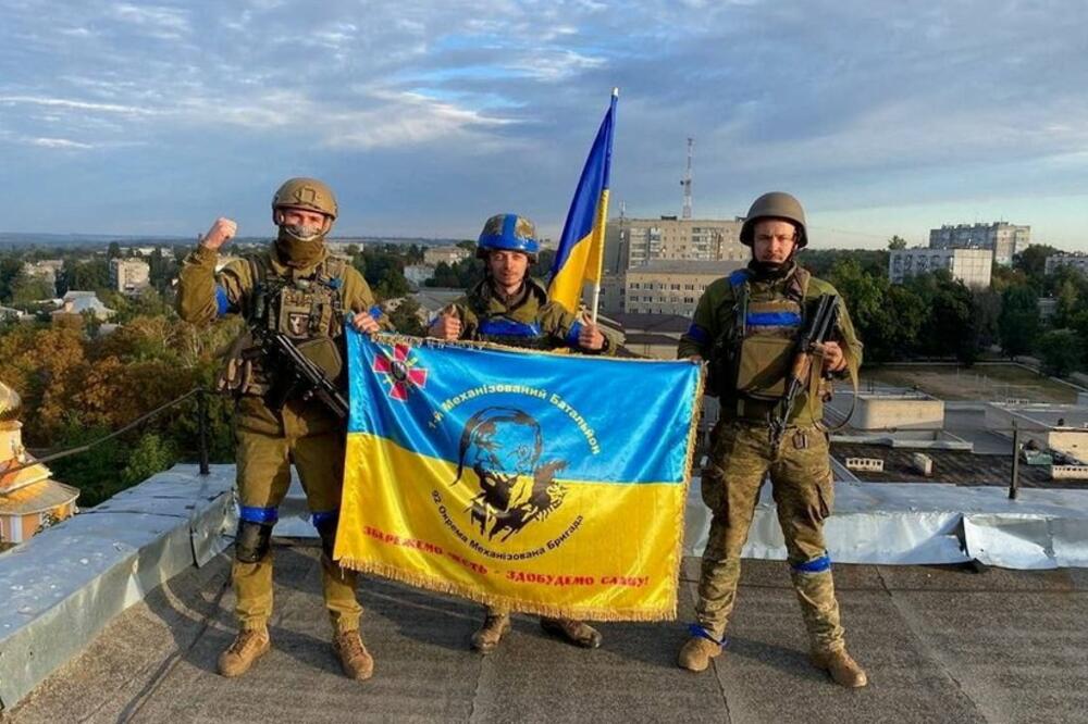 Ukrajinski vojnici sa zastavom na krovu zgrade u gradu Kupjansku, 10 septembar 2022., Foto: Reuters via TELEGRAM @KUPTG