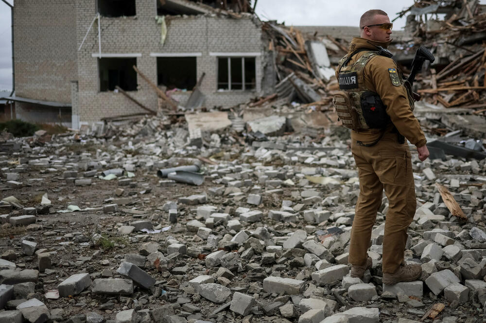 Pripadnik ukrajinskih snaga pored uništene škole, Foto: Reuters