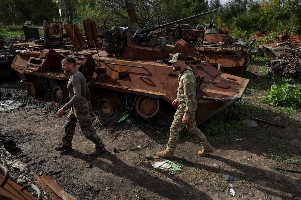 Ukrajinski vojnici pored uništenog ruskog oklopnog vozila u Izjumu, Foto: Rojters