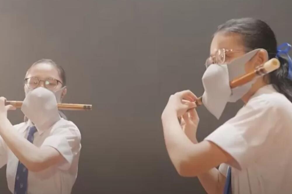 Korisnici društvenih mreža ismejali su video na kojem su prikazane dve učenice koje sviraju flautu dok nose po dve maske, Foto: HONG KONG EDUCATION BUREAU