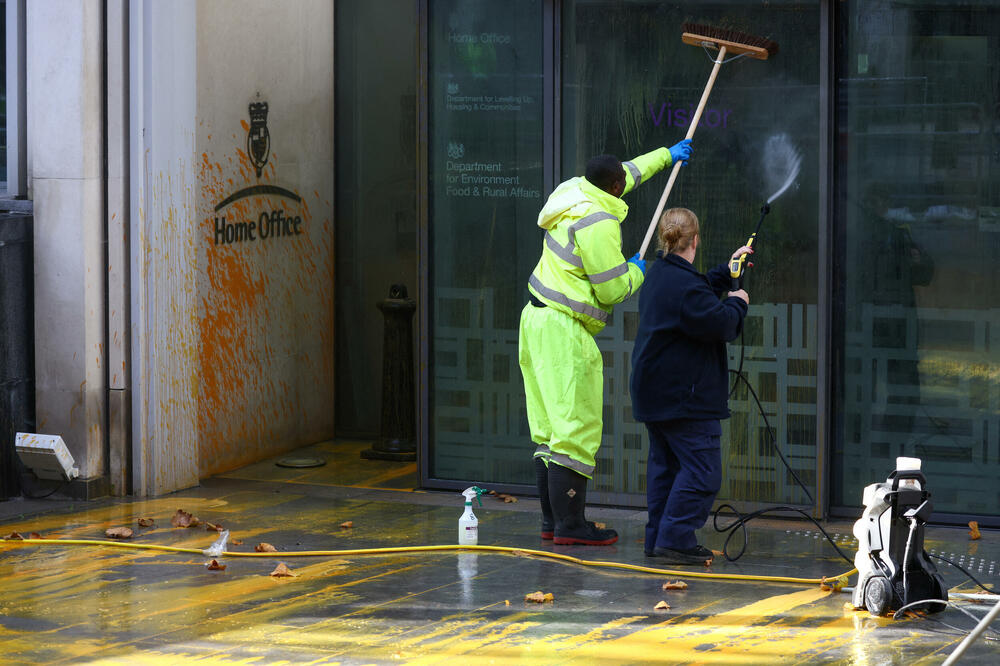 Radnici čiste boju kojom su aktivisti u Londonu poprskali zgradu Ministarstva unutrašnjih poslova, Foto: Reuters