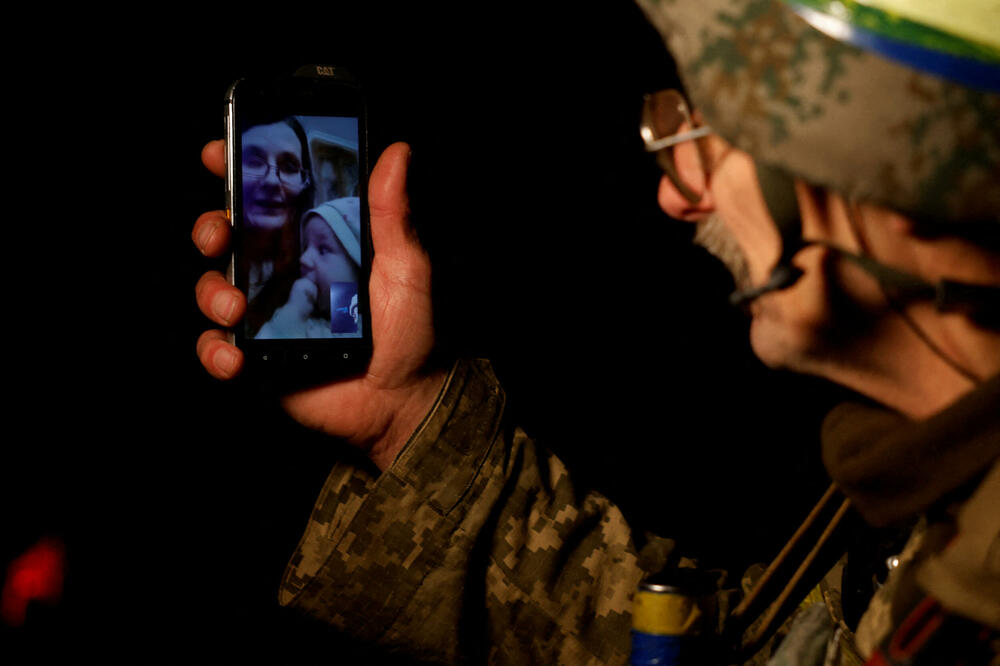Ukrajinski vojnik na ratištu razgovora sa porodicom putem telefona, Foto: Rojters
