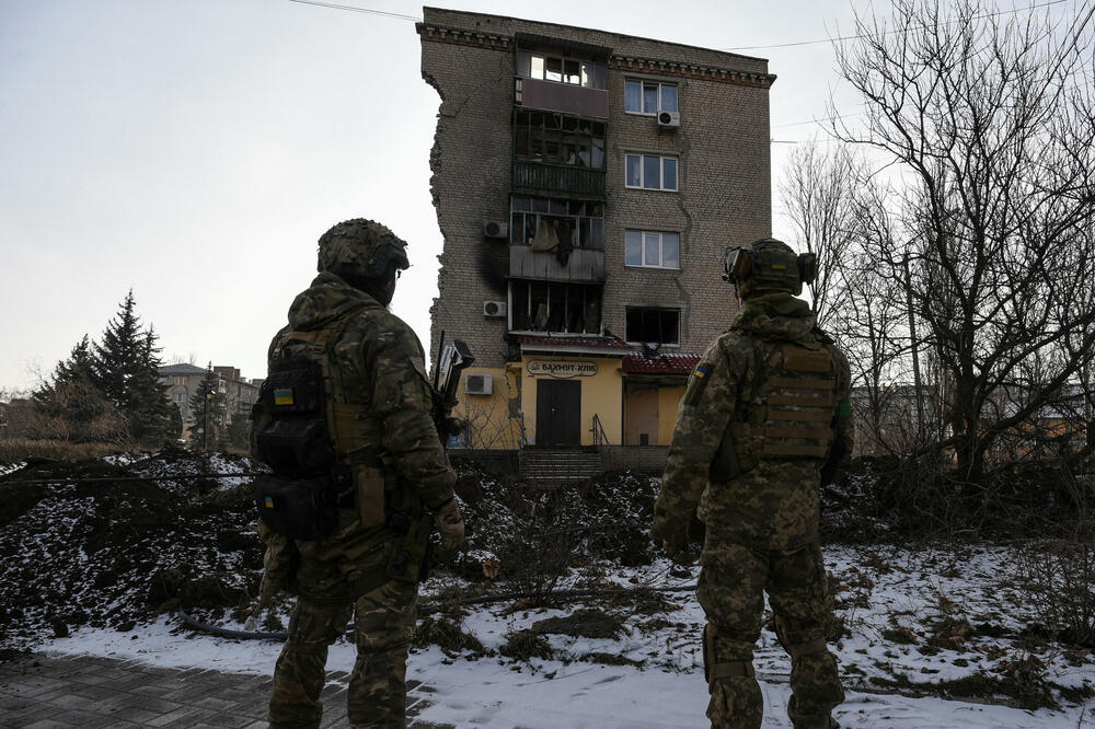 Ukrajinski vojnici stoje pored stambene zgrade teško oštećene tokom ruskog vojnog udara u Bahmutu, Foto: Reuters