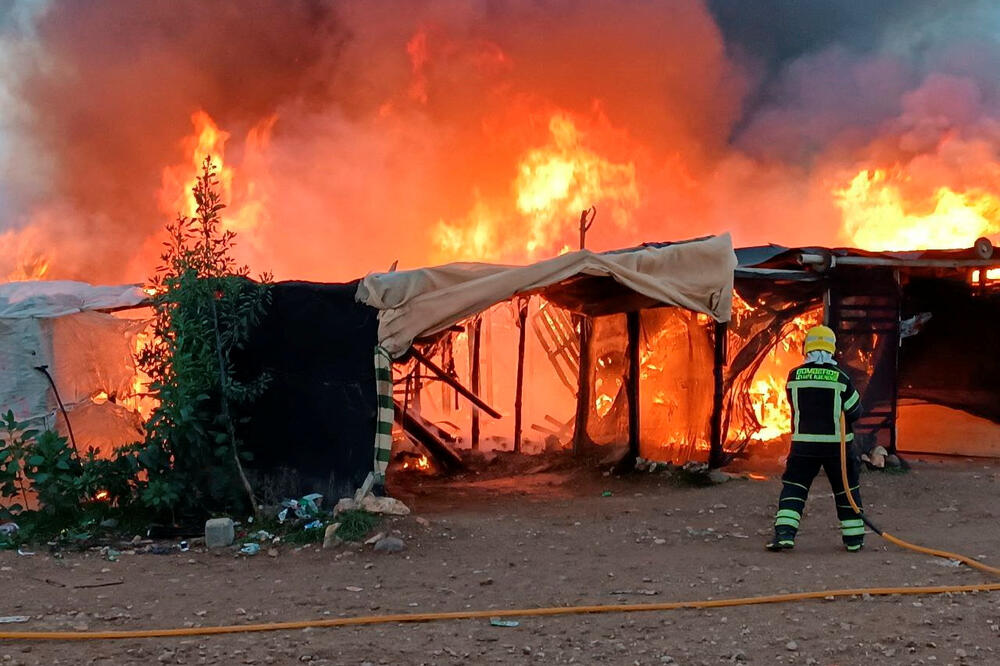 Vatrogasac gasi požar u kampu za migrante, Foto: REUTERS