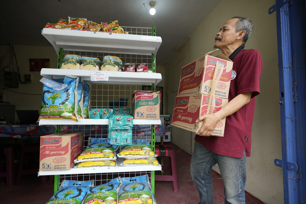Ulični prodavac, Mukroni, raspoređuje kutije u svojoj radnji u predgrađu Džakarte