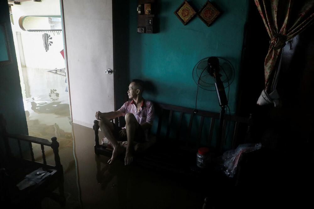 Jedan od stanovnika malezijske države Džohor tokom poplava, Foto: Reuters