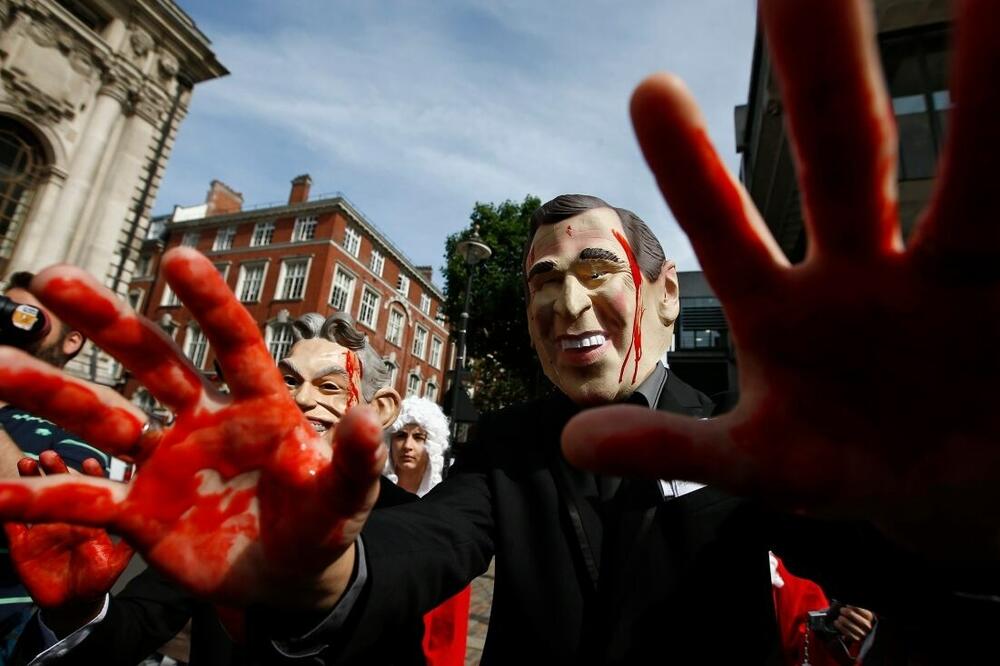 Demonstranti sa maskama Tonija Blera i Džordža Buša prije objavljivanja izvještaja Džona Čilkota o ratu u Iraku, jul 2016, Foto: Rojters