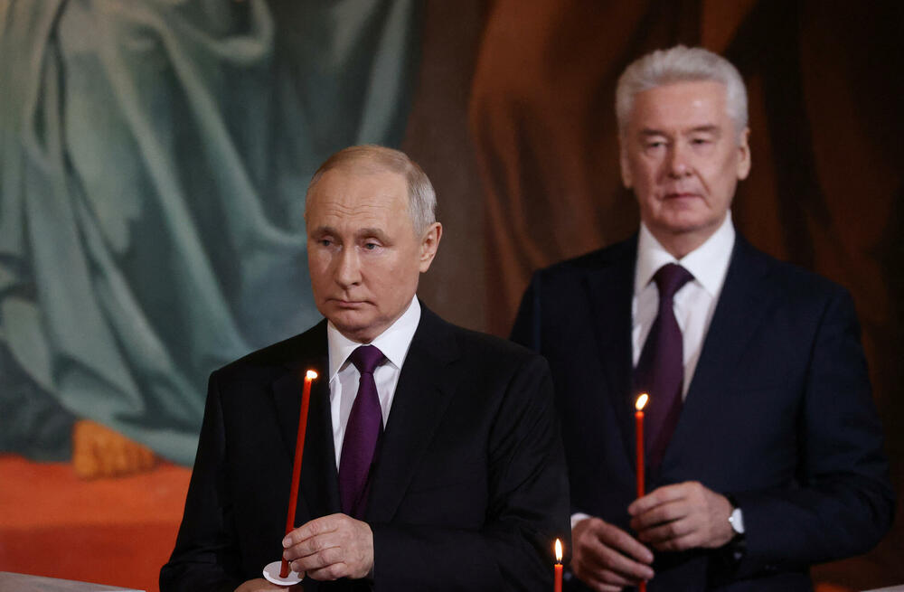 <p>Putin, obučen u tamno odijelo, bijelu košulju i tamnoljubičastu kravatu, stajao je sa strane u moskovskoj katedrali Hrista Spasitelja, držeći upaljenu crvenu svijeću</p>