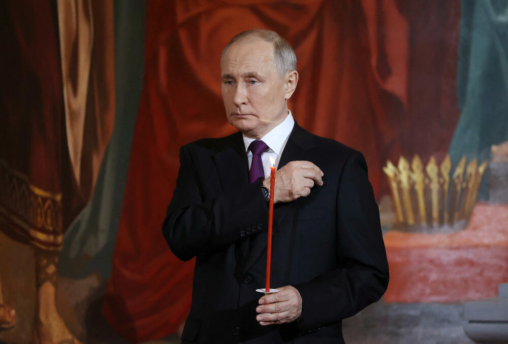 <p>Putin, obučen u tamno odijelo, bijelu košulju i tamnoljubičastu kravatu, stajao je sa strane u moskovskoj katedrali Hrista Spasitelja, držeći upaljenu crvenu svijeću</p>