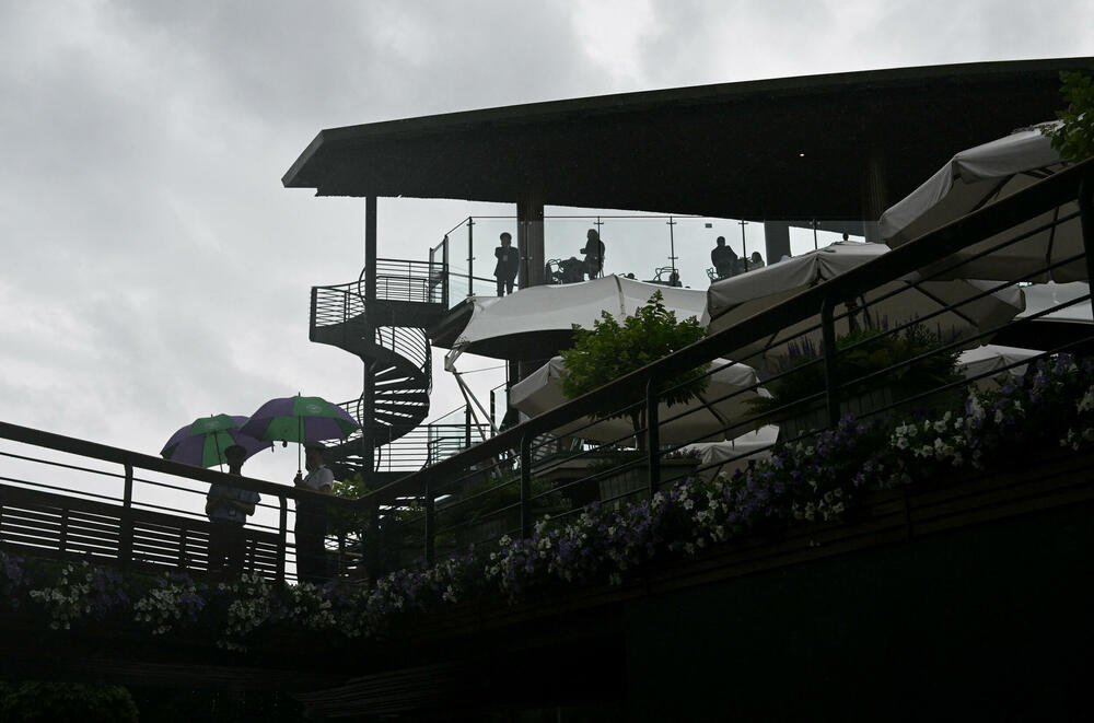 <p>Kiša je dio tradicije na Vimbldodonu, kišobrani su najprodavaniji rekviziti, a ovakvi dani "poslastica" su i za fotoreportere</p>