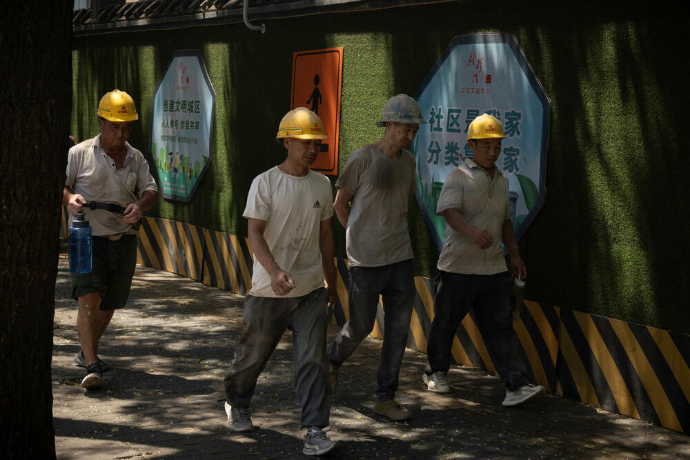 Radnici snimljeni na jednoj od ulica u Pekingu