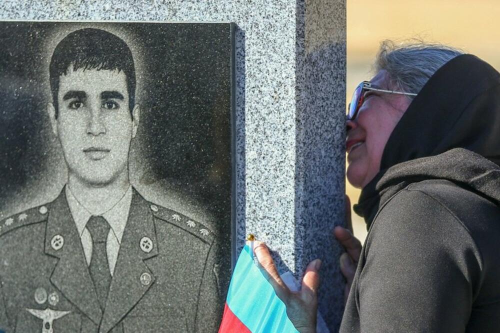 Žena ljubi spomenik azerbejdžanskog vojnika koji je poginuo u sukobu u regionu Nagorno-Karabah, Foto: Reuters