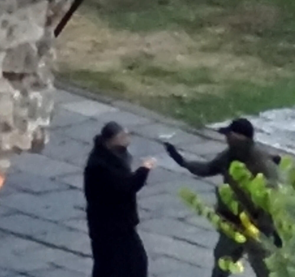 Naoružana osoba razgovara sa sveštenikom u Manastiru Banjska