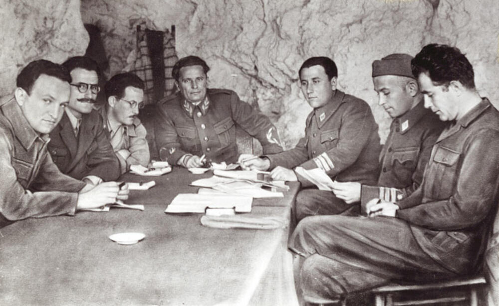 Vrhovni štab NOVJ u pećini na Visu 1944. godine: Vladimir Bakarić, Ivan Milutinović, Edvard Kardelj, Josip Broz Tito, Aleksandar Ranković, Svetozar Vukmanović Tempo, Milovan Đilas.