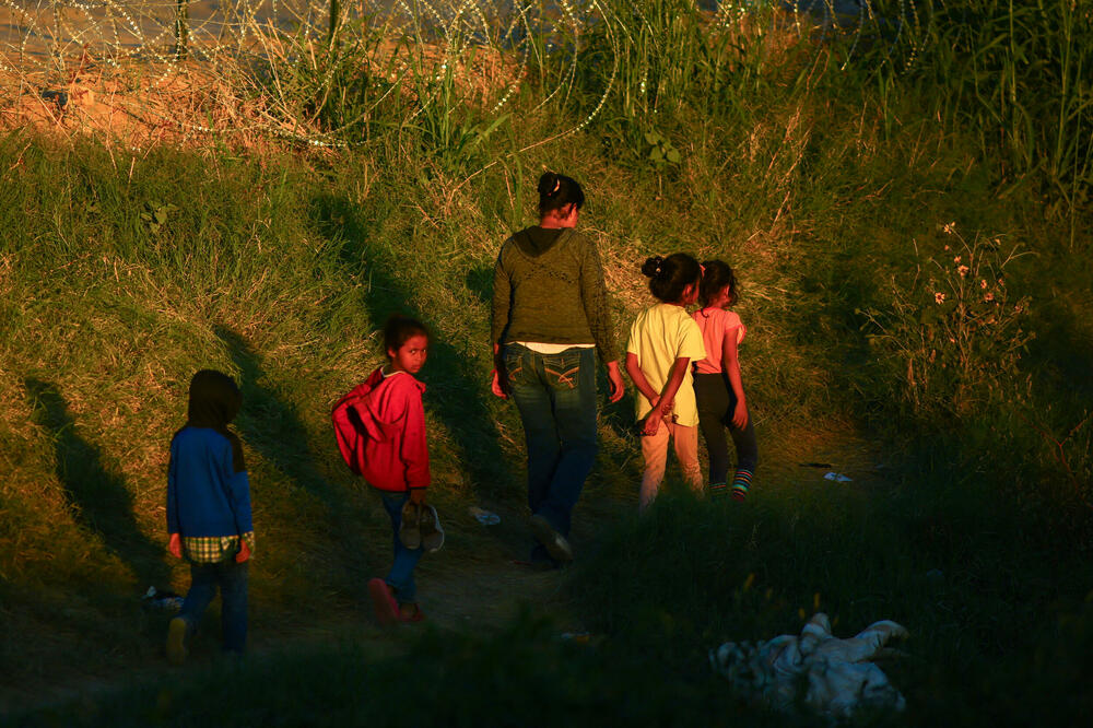 Migranti koji traže azil u Sjedinjenim Državama prolaze pored žičane ograde postavljene da spriječi prelazak migranata u SAD, Foto: Reuters