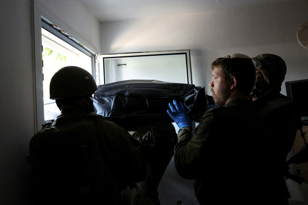 Tijelo starije žene iznosi se iz njene kuće nakon napada militanata na kibuc Kfar Aza, Foto: Reuters