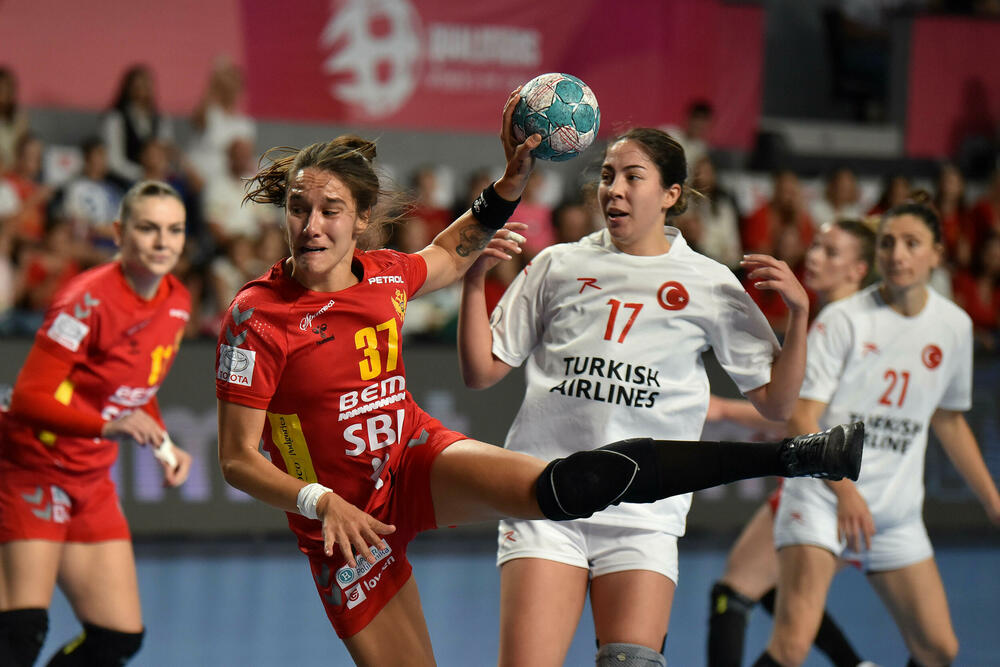 <p>Pogledajte foto-galeriju sa utakmice Crna Gora - Turska, koju su „lavice” dobile 39:23 i pokazale da i na Svjetskom prvenstvu mogu da igraju dobar rukomet.</p>  <p>Utakmica je imala dirljivu predigru, jer su se igračice pojavile u majicama sa fotografijom povrijeđene Đurđine Jauković i natpisom „Điki, uz tebe smo”.</p>  <p>Nikšićka bombarderka, koja je prošle sedmice drugi put pokidala prednji ukršteni ligament lijeve noge, bila je na tribinama „Bemax arene”.</p>