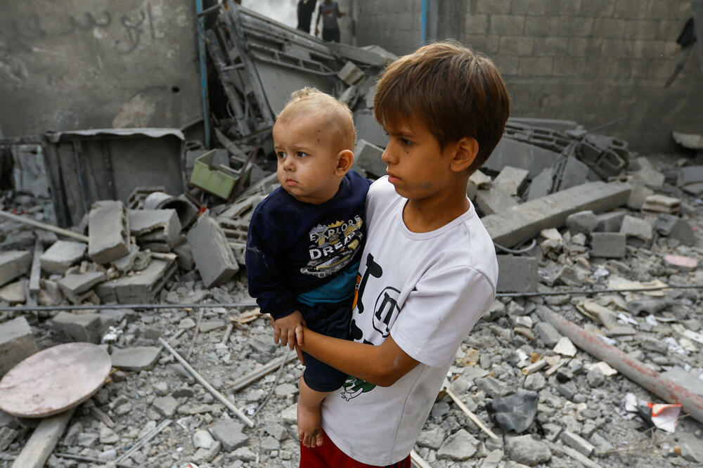 Palestinska djeca stoje među ruševinama i gledaju tokom potrage za žrtvama nakon izraelskih udara na kuće, u Kan Junisu, u južnom pojasu Gaze, Foto: Reuters