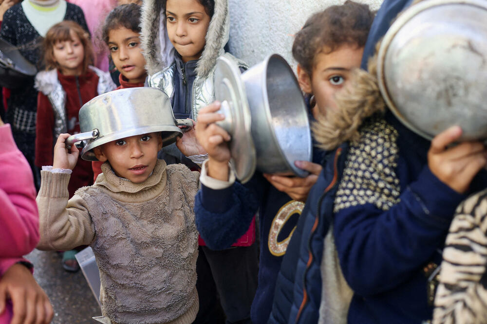 Palestinska djeca u redu za hranu koju spremaju humanitarci u Rafi, Foto: Rojters