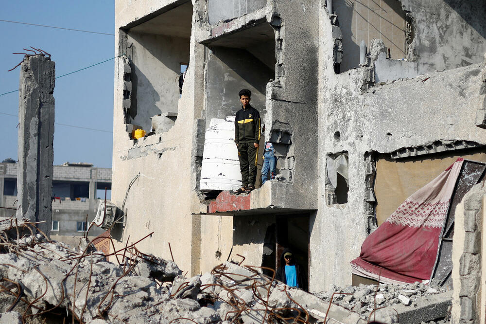 Palestinci u kući uništenoj u izraelskom napadu u Rafi na jugu Gaze, Foto: Rojters