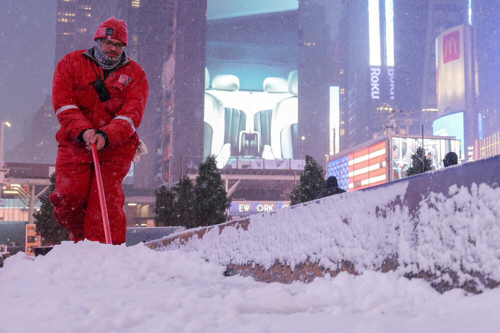 Radnik čisti snijeg na Tajms skveru tokom prve snježne padavine za više od 700 dana u Njujorku, Foto: Reuters